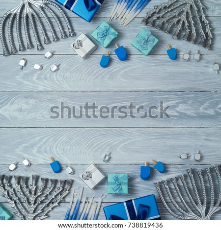 Hanukkah background with menorah, gift box and dreidel over wooden table. View from above. Flat lay