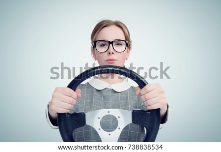 Young girl in glasses with steering wheel, auto concept 