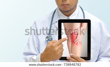 Doctor pointing on tablet screen showing picture of women who have knee pain.
