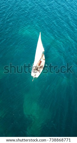 Aerial drone, bird's eye view of yacht cruising in tropical turquoise and sapphire sea