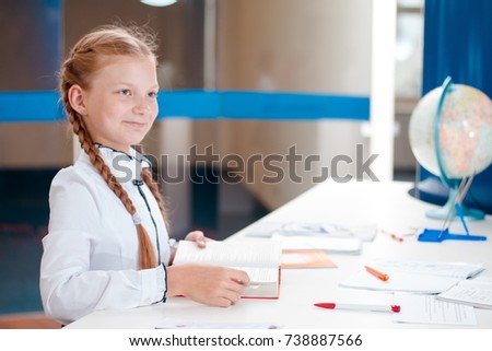 blonde girl in white blouse posing in school classroom