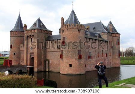 The Muiderslot or Castle of Muiden, the famous medieval castle in Netherlands. A tourist is taking pictures.