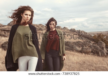 Outdoor fashion portrait of two beautiful stylish ladies in trendy and fashion cardigans. Casual look. Street style. Royalty-Free Stock Photo #738937825