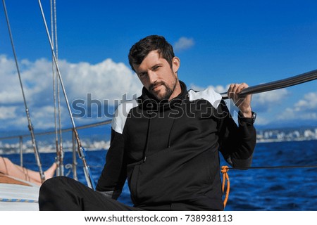 man in black on the sailboard sit