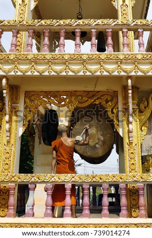 monk  with hammer on gong