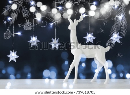White reindeer on wooden table over chalkboard background with hand drawn chalk illustrations