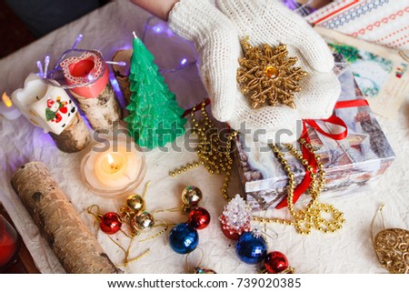 A composition of Christmas toys and hands with white mittens