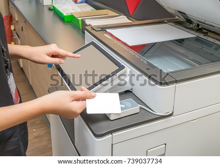 Women hold card for scanning key card to access Photocopier Security system concept Royalty-Free Stock Photo #739037734