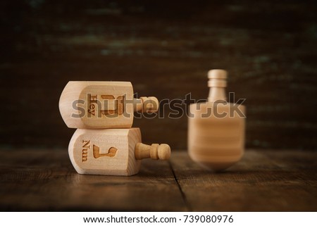 Image of jewish holiday Hanukkah with wooden dreidels colection (spinning top) and glowing gold lights on the table