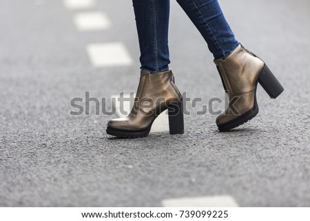 Model posing for pictures outside on the grey pavement. Skinny jeans with leather vintage style shoes.