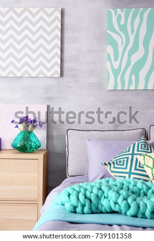 Lilac accent in modern interior. Comfortable bed with pillows and plaid in room