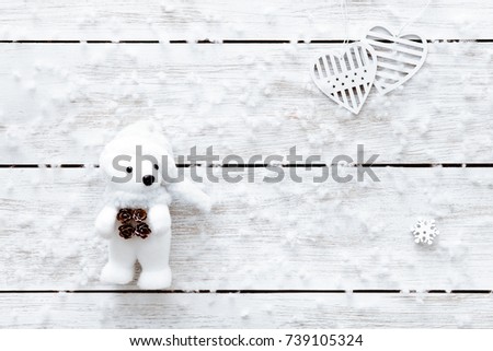 Valentines day card, snowflakes, hearts and toy bear on light wooden table, white flakes of snow on xmas desk, merry Christmas holiday background or romantic happy new year, top view, copy space