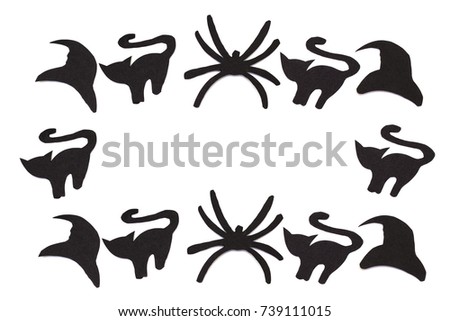 Silhouettes of black cats and spiders and hats carved out of black paper are isolated on white for Halloween festival. Halloween concept