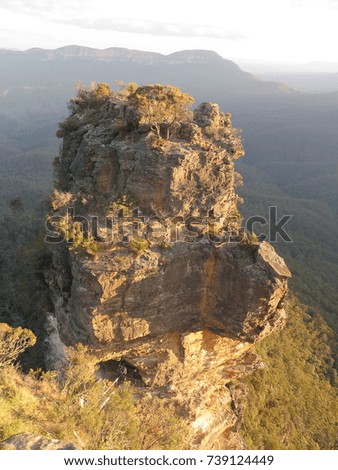 A rock in the foreground on a vertical picture with mountains in background