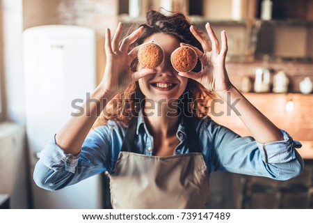 Attractive young woman is cooking on kitchen. Having fun while making cakes and cookies. Royalty-Free Stock Photo #739147489