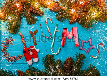 Image of blue table with spruce branches, word Christmas