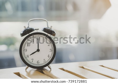 Retro alarm clock on wooden table, vintage style