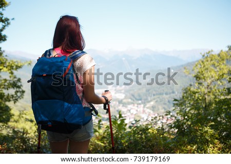 Photo from back of young woman with sticks for sporty walk