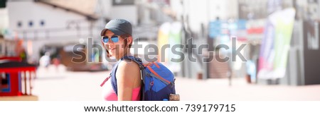 Panoramic photo of smiling woman with backpack