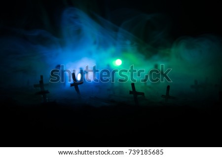 Silhouette of zombies walking over cemetery in night. Horror Halloween concept of group of zombies at night. Selective focus
