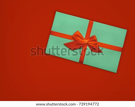 Gift box Bright styled photo Turquoise gift box with orange ribbon on scarlet background Top view Photo mockup with space for text