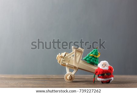 Decoration & Ornament merry Christmas and Happy new year concept.Santa claus and airplane transfer offloading fir tree.Essential accessories on modern brown rustic wooden at home office desk. 