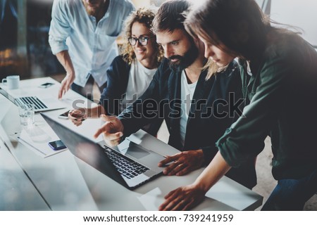 Working process at office.Group of young coworkers work together modern coworking studio.Young people making conversation with partners.Horizontal.Blurred background Royalty-Free Stock Photo #739241959