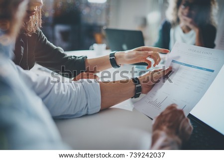 Young people making conversation with partners at the table.Man holding paper document in hand. Horizontal.Blurred background