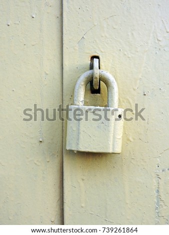 The old padlock is pale yellow.