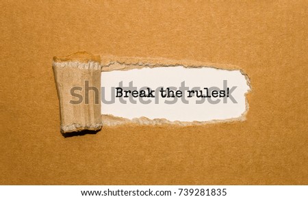The text Break the rules appearing behind torn brown paper