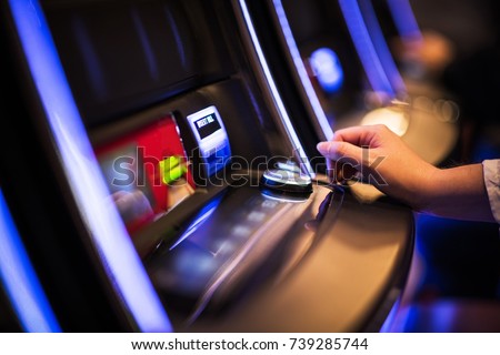 Casino Slot Machine Games Playing. Woman Hand on the Machine Bet Button. Closeup Photo Royalty-Free Stock Photo #739285744