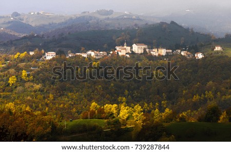 Village in the countryside at fall season, with cloudy mountains in the background