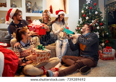 Group happy of friends laughing and sharing Christmas gifts
