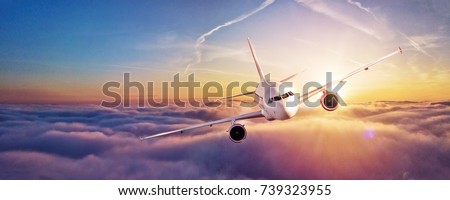 Commercial airplane flying above clouds in dramatic sunset light. High resolution of image. Fast Travel and transportation concept Royalty-Free Stock Photo #739323955