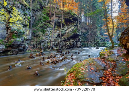czech mountain wild river Doubrava in Czech Republic with slow shutter speed. Valley in beautiful autumn fall colors. Picturesque landscape.