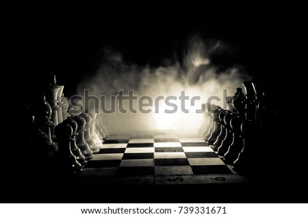 Chess board game concept of business ideas and competition and strategy ideas concep. Chess figures on a dark background with smoke and fog. Selective focus Royalty-Free Stock Photo #739331671