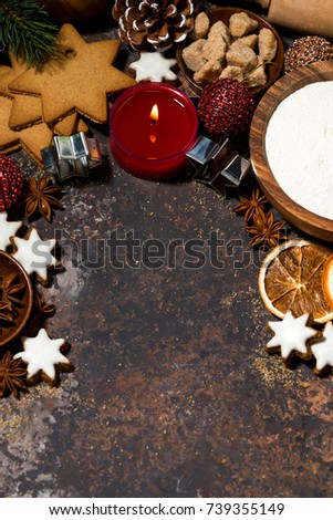 dark background with ingredients for baking Christmas cookies and candle, top view vertical