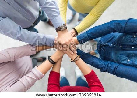 Close up top view of young business people putting their hands together. Stack of hands. Unity and teamwork concept. Royalty-Free Stock Photo #739359814