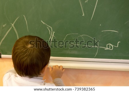Baby drawing on the blackboard