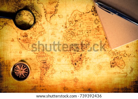 An ancient map, a compass and a magnifying glass