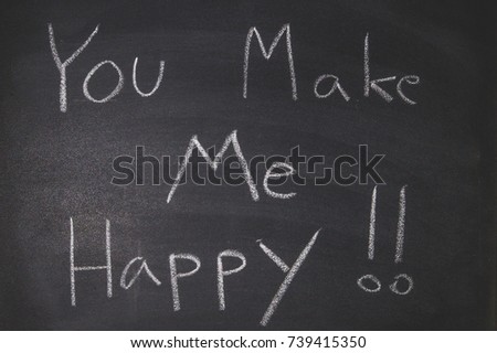The blackboard writing with chalk and the concept of business and finance, Blackboard with chalk to write the text "YOU MAKE ME HAPPY"