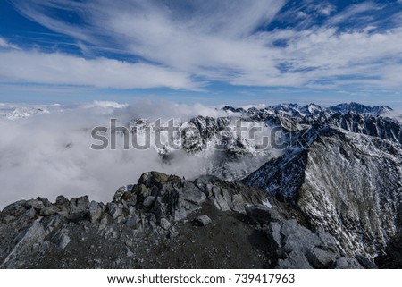 panoramic view of Tatra mountains in Slovakia covered with snow and hiding in mist. high altitude