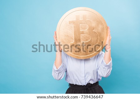 Funny woman holding a Golden Bitcoin. virtual money. Royalty-Free Stock Photo #739436647