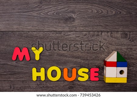 Word House from wooden letters on wooden background