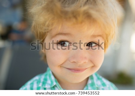 Cunning boy, trick at cute baby face. Children's emotion, smart baby boy. Funny face of adorable child. Kid portrait with smile and cheerful eyes. Awesome boy looks at something and wants to buy