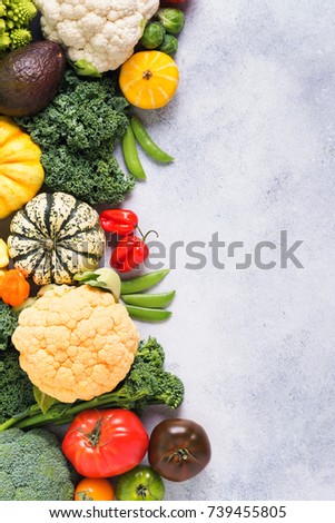 Above view of different colored rainbow vegetables on the light grey background, copy space for text, vertical, selective focus