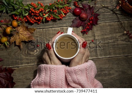 women's hands with bright manicure hold a cup of coffee, autumn cozy mood. toned picture