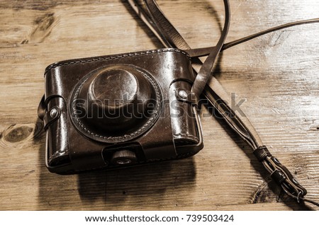 vintage photo camera leather case over wood background