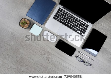 Office table with laptop computer, notebook, digital tablet, pen, smartphone, mouse, eyeglasses and coffee on white wood background. Desktop office mockup concept.