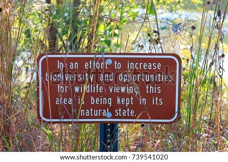 a brown nature sign asking to preserving biolife around the area. 